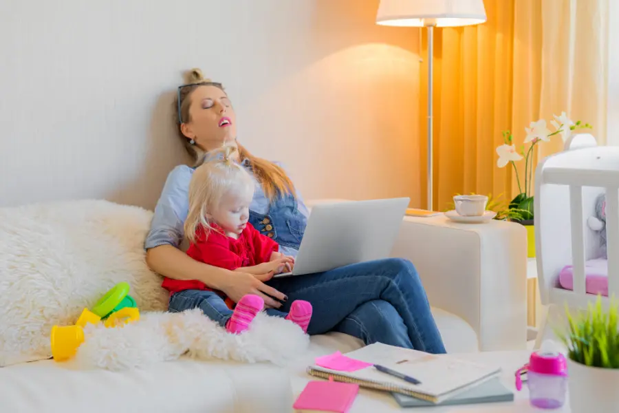 Donna che cucina e accudisce i figli, simbolo del lavoro domestico non retribuito e del costo invisibile della maternità