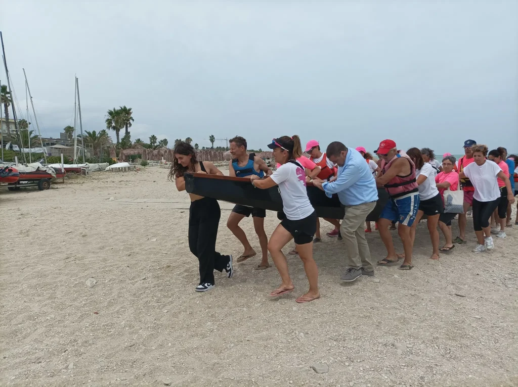 Le Dragonesse dell'associazione Infinitae, che supporta donne operate di tumore al seno, assieme a tanti supporter riportano a riva con la forza delle braccia il Dragon boat, l'imbarcazione con la testa e la coda di un drago in cui pagaiano in mare al ritmo di un tamburo